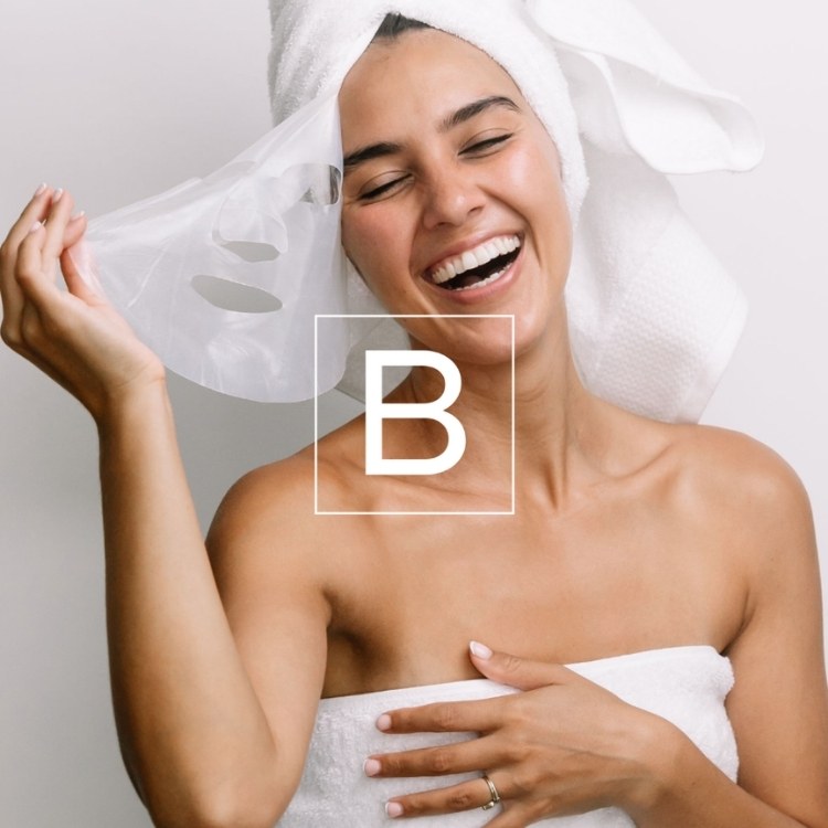 Woman wrapped in a towel with a white 'B' logo on a light background
