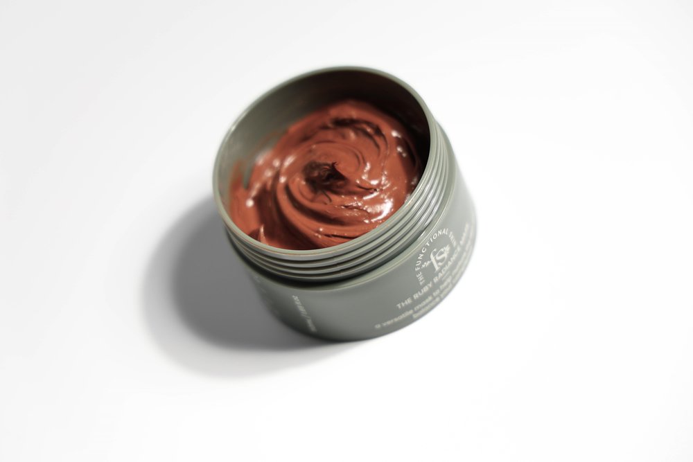 Opened jar of the ruby face mask on a white background 