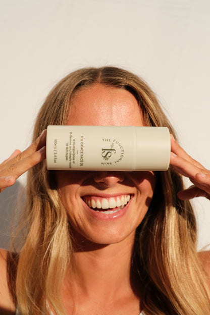 The grace face oil in front of a women smiling