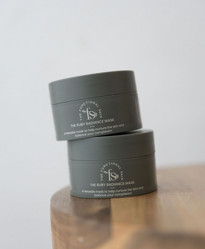 Two green jars of the ruby face mask on a table 