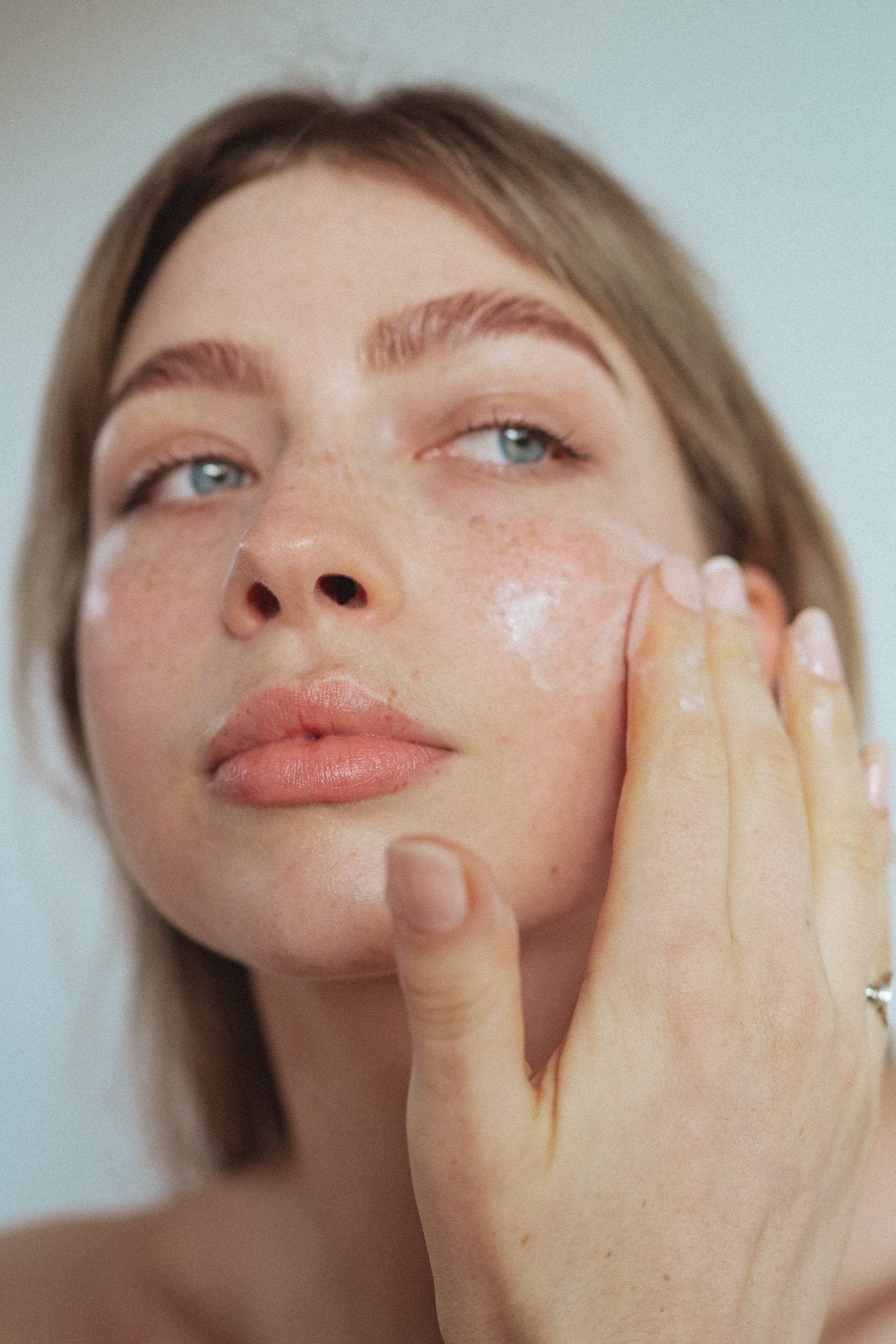 Close up of a women's face while she puts on skincare